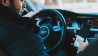 A man looking at his phone while sitting in a car